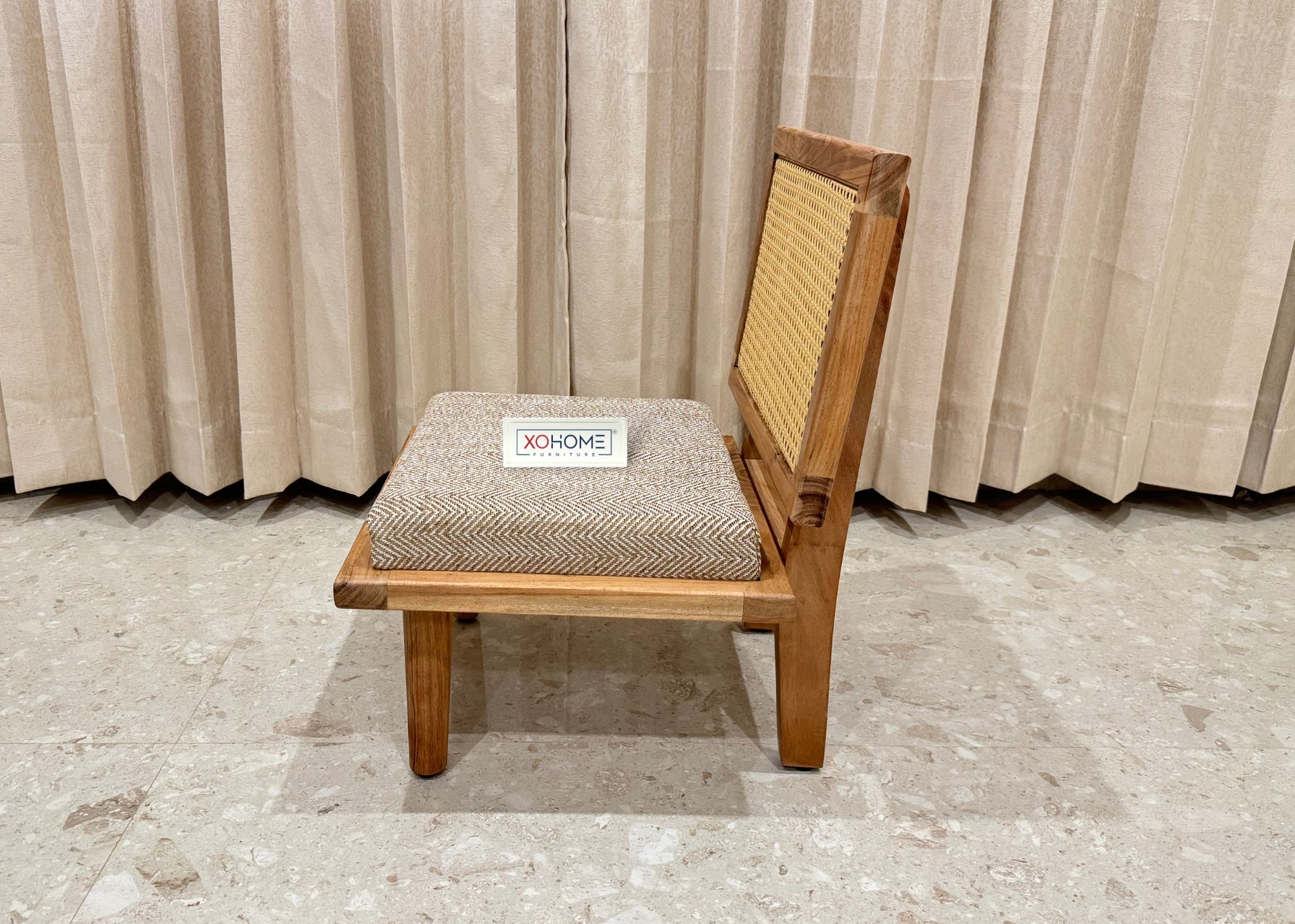 Bhumi Low Seating Chair by XOHOME – A beautifully crafted pure solid wood floor chair with a stylish rattan backrest, padded seat for extra comfort, and a lightweight design for easy mobility. Perfect for everyday use, reading nooks, meditation spaces, and cozy corners. Dimensions: Height – 23.5”, Width – 18”, Depth – 18”.