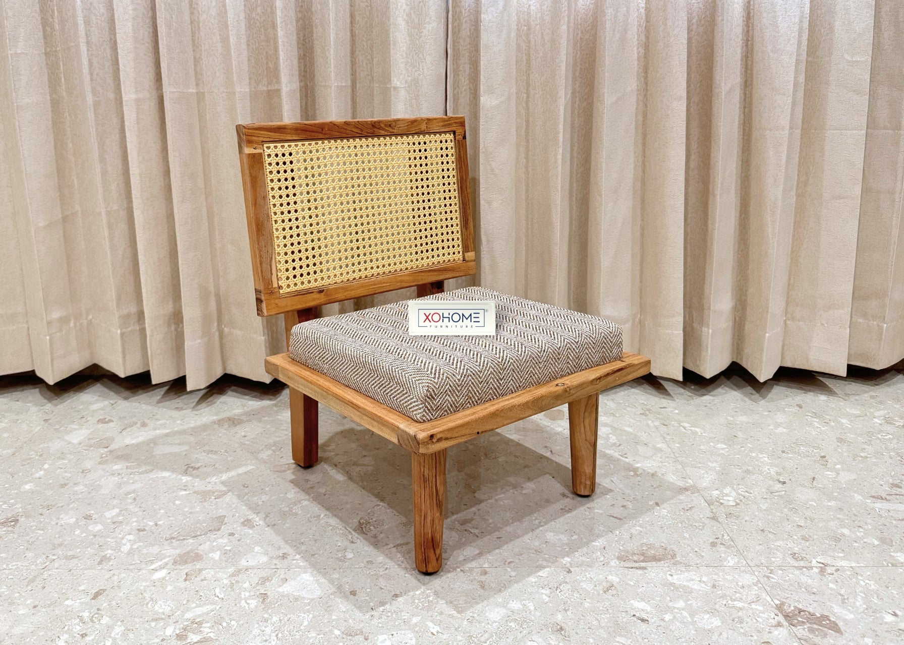 Bhumi Low Seating Chair by XOHOME – A beautifully crafted pure solid wood floor chair with a stylish rattan backrest, padded seat for extra comfort, and a lightweight design for easy mobility. Perfect for everyday use, reading nooks, meditation spaces, and cozy corners. Dimensions: Height – 23.5”, Width – 18”, Depth – 18”.